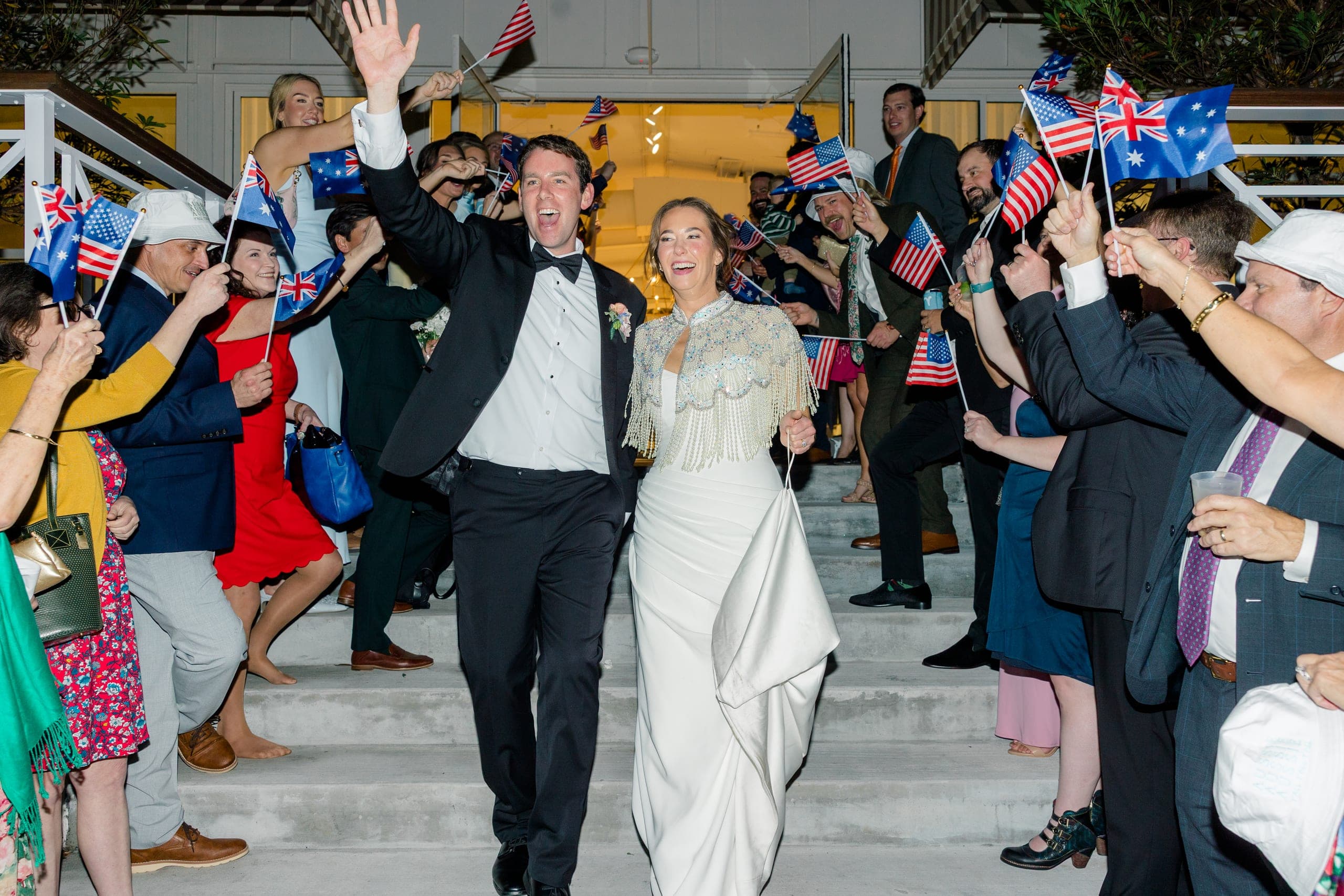 Joyful wedding exit with flags