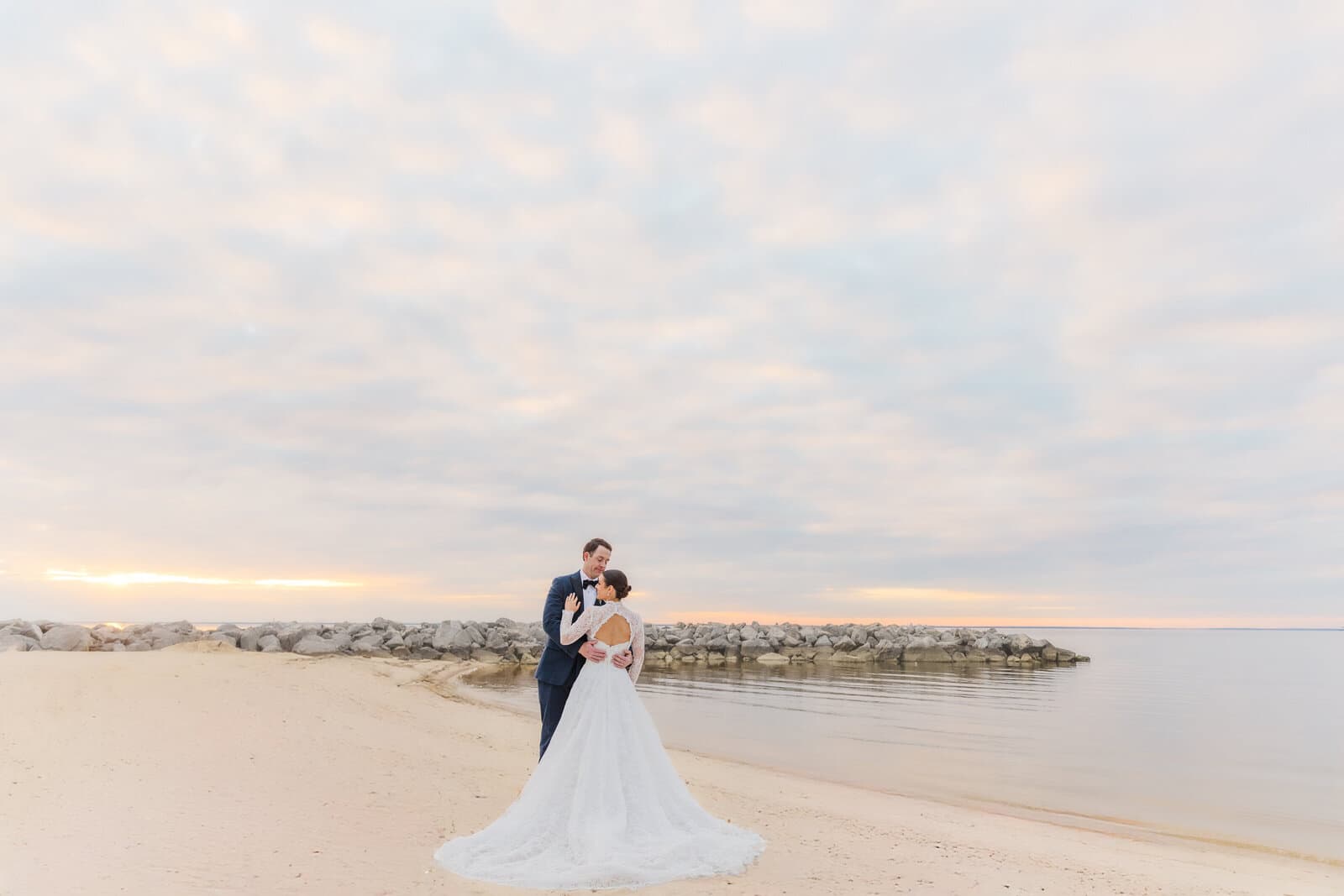 A newlywed couple embracing on the beach