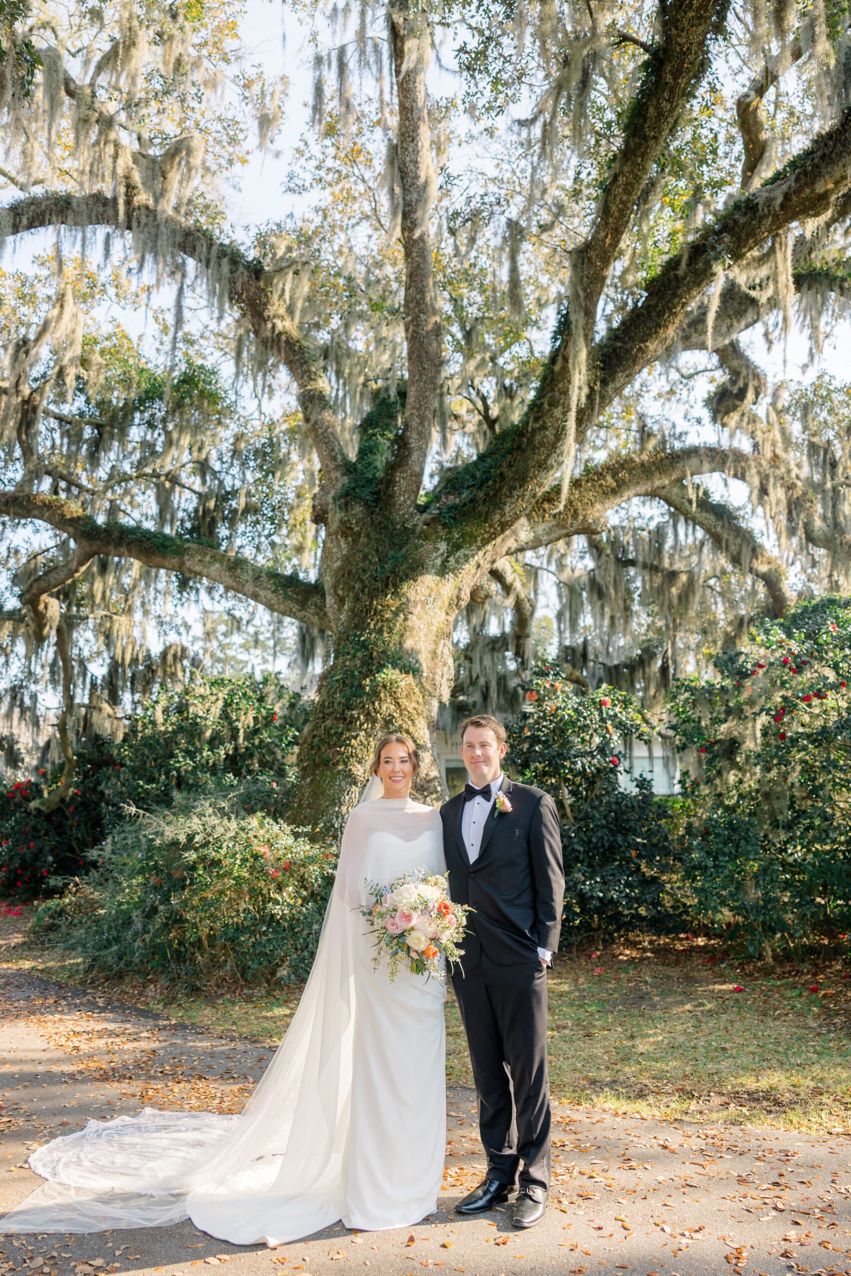 Bride and groom beneath a moss-draped oak tree