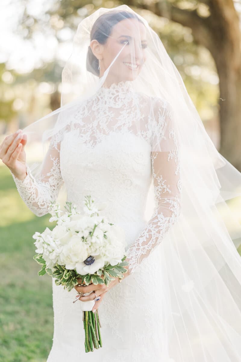 Bride holding her bouquet beneath a soft veil
