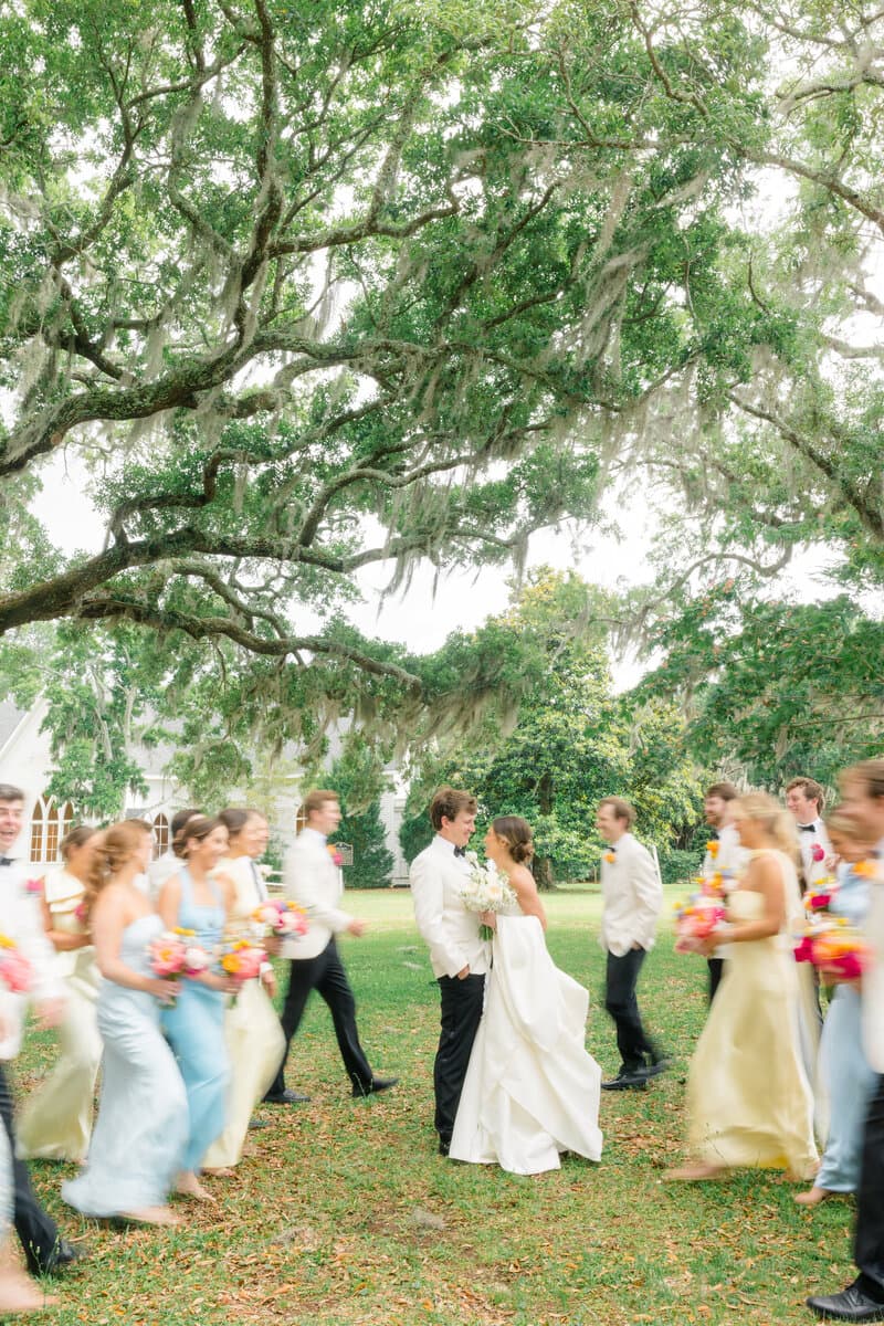 Newlyweds walking through a joyful flower-petal exit