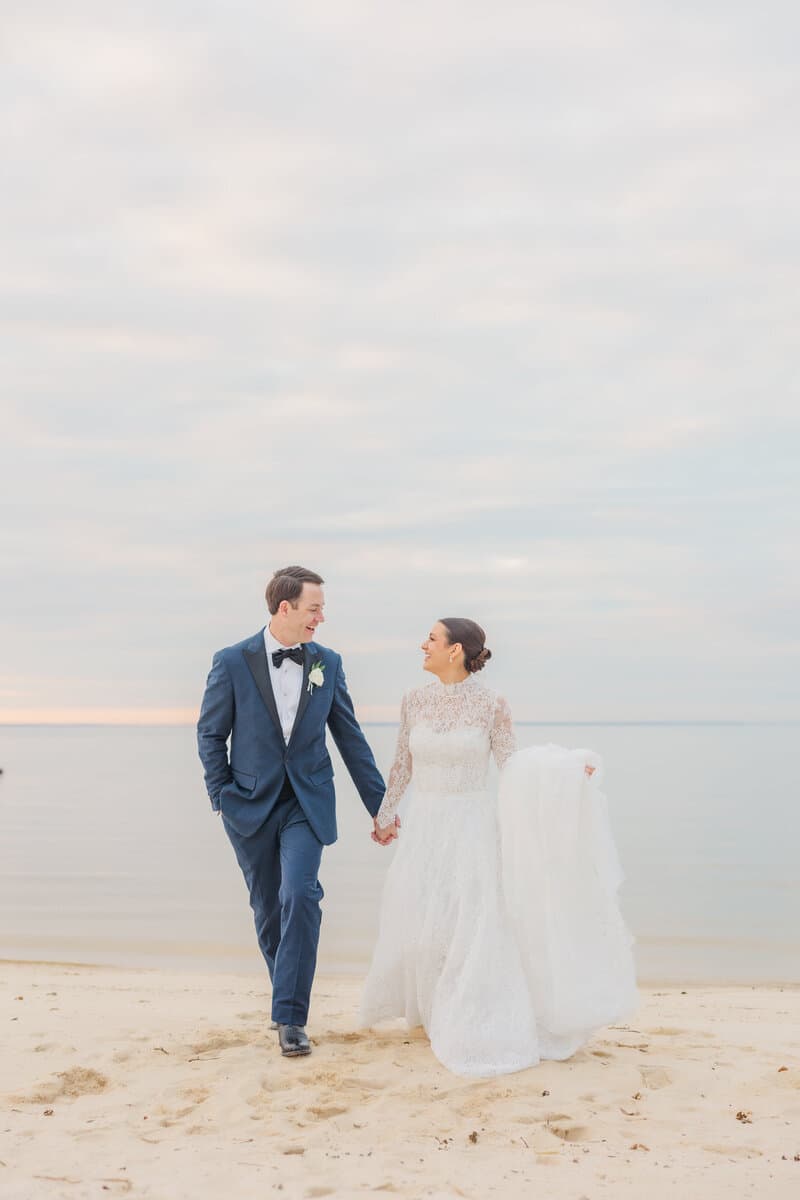 Bride and groom walking together on the beach