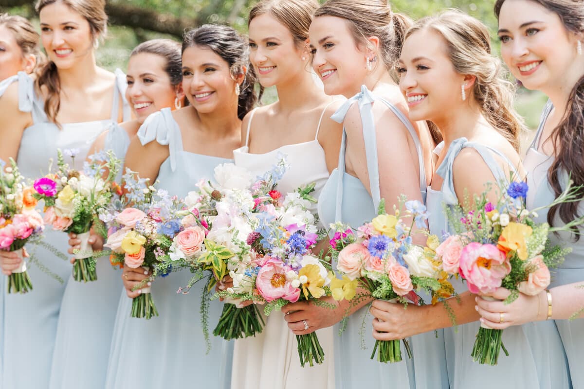 Bridesmaids carrying bright spring bouquets