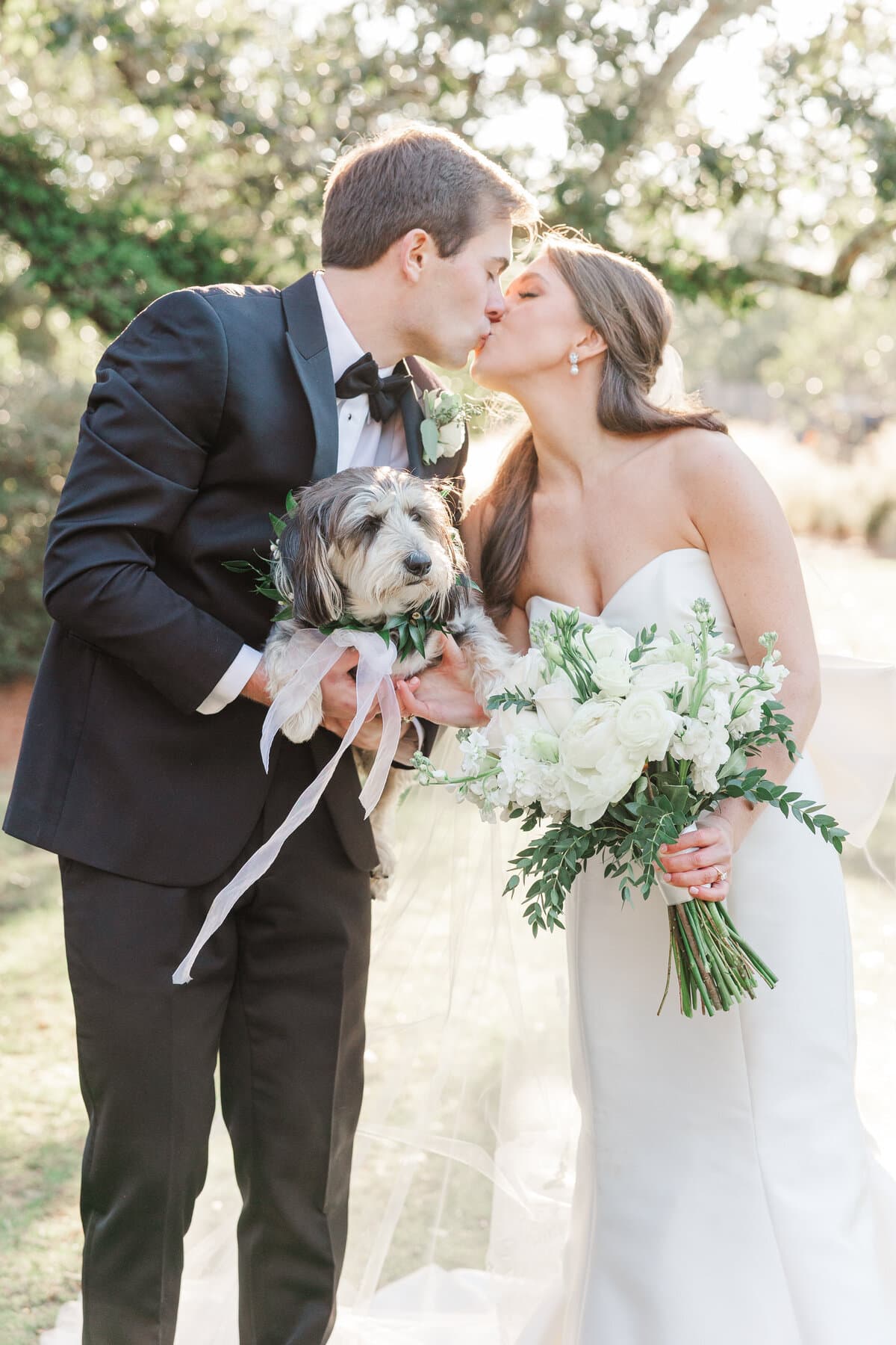 Newlyweds posing with their dog after the ceremony