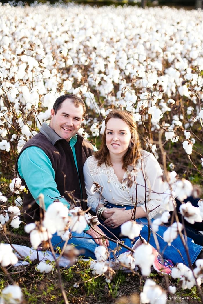 Josh and Lindsey seated together in a blooming Alabama cotton field