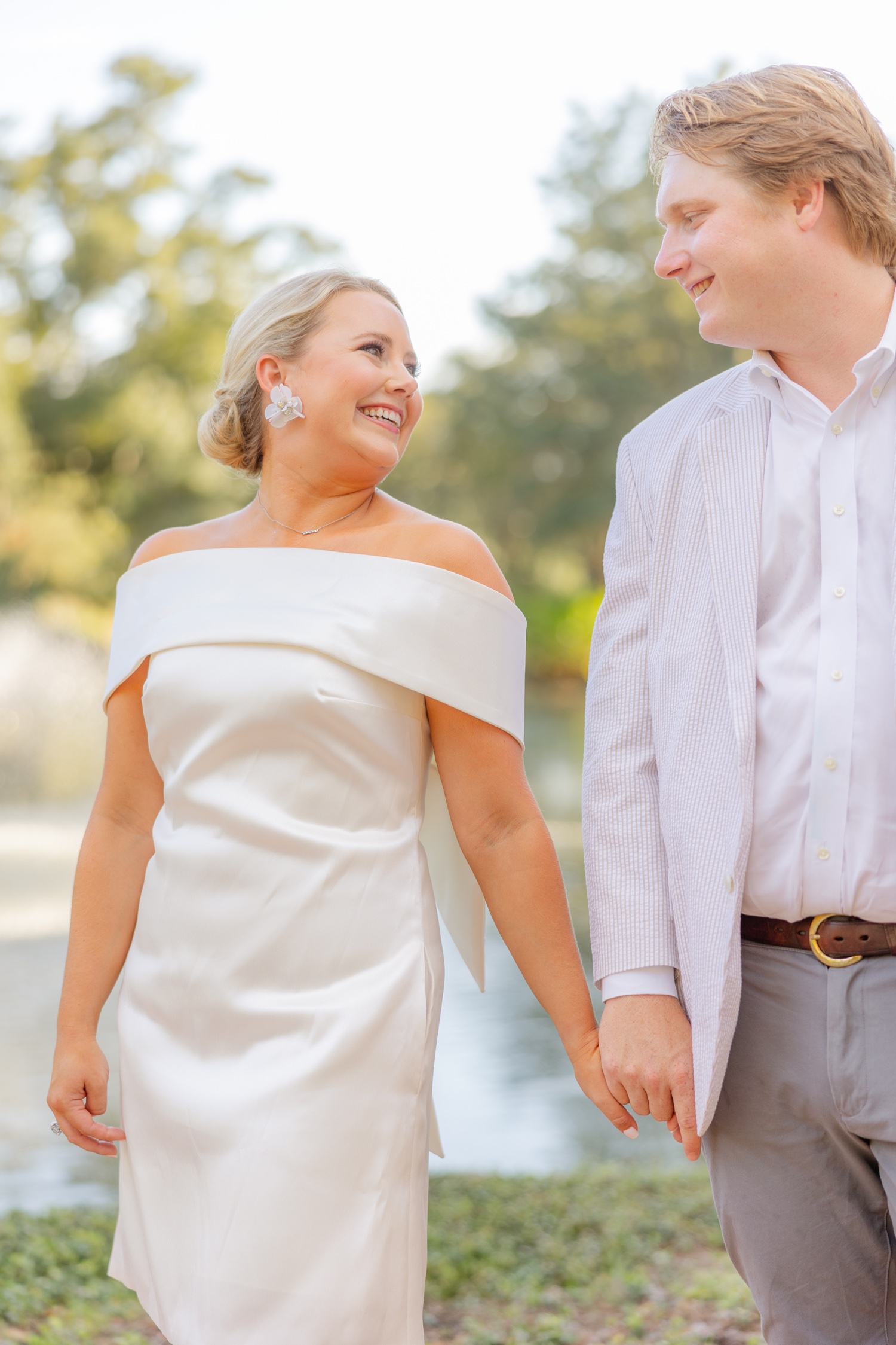 Romantic couple Audrey and Lyon, bathed in soft sunlight, share a loving moment beneath the mossy oak trees at the picturesque Grand Hotel in Fairhope.