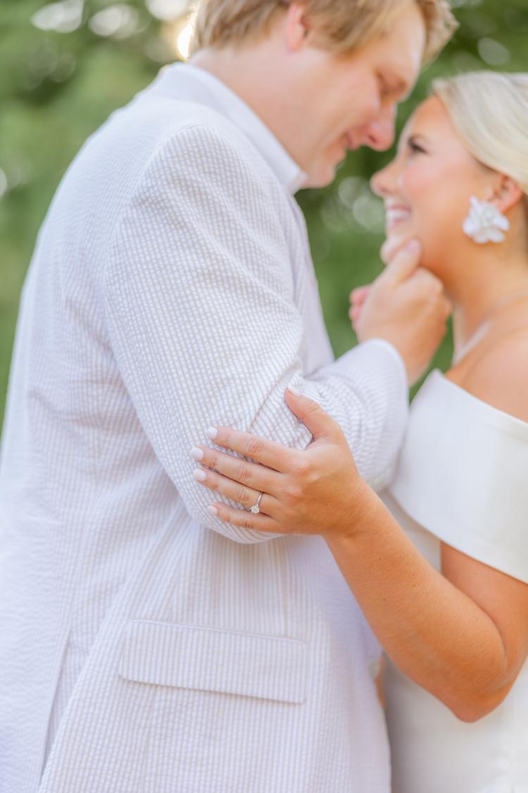 Romantic couple Audrey and Lyon, bathed in soft sunlight, share a loving moment beneath the mossy oak trees at the picturesque Grand Hotel in Fairhope.