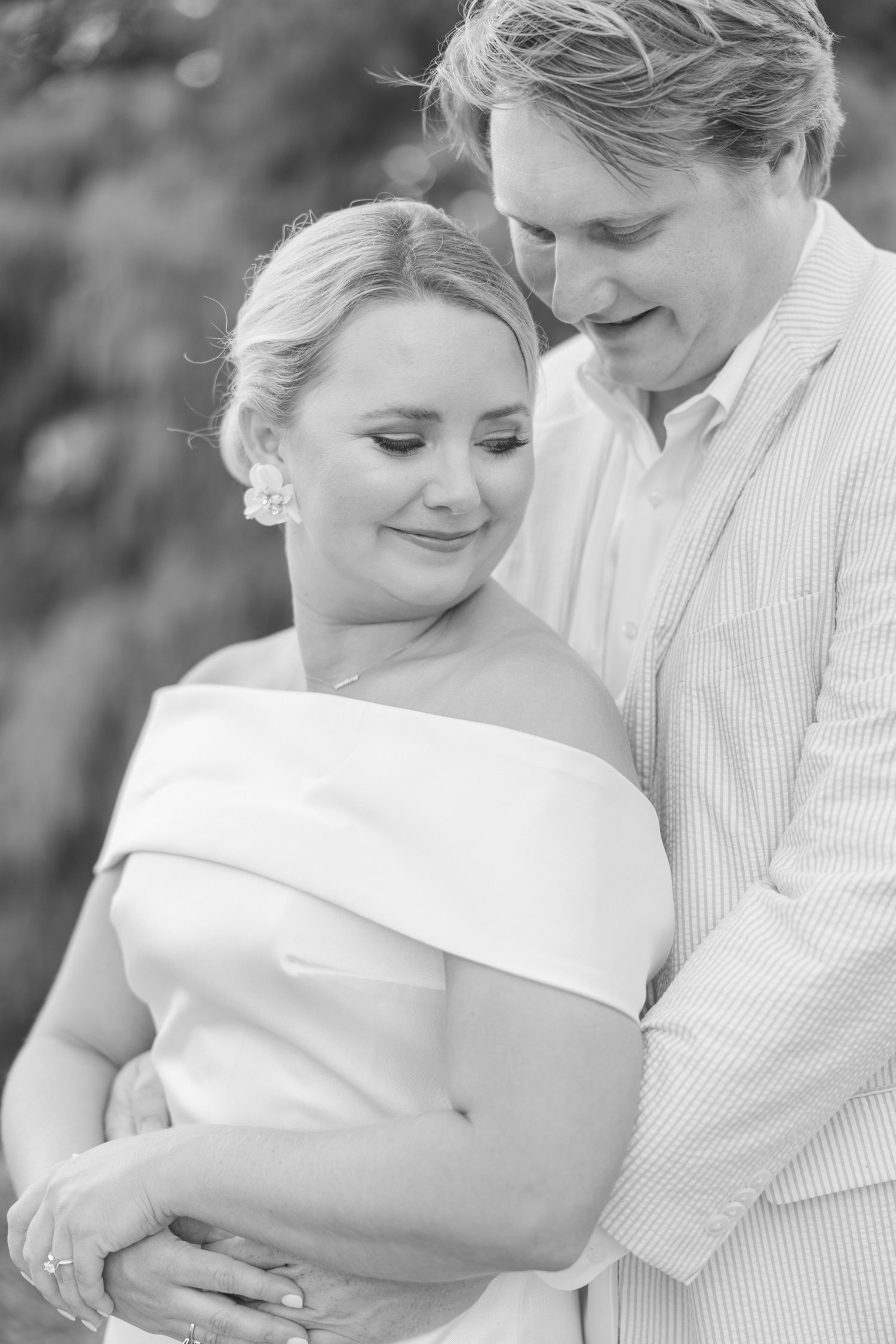 Romantic couple Audrey and Lyon, bathed in soft sunlight, share a loving moment beneath the mossy oak trees at the picturesque Grand Hotel in Fairhope.