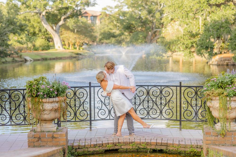 Romantic couple Audrey and Lyon, bathed in soft sunlight, share a loving moment beneath the mossy oak trees at the picturesque Grand Hotel in Fairhope.