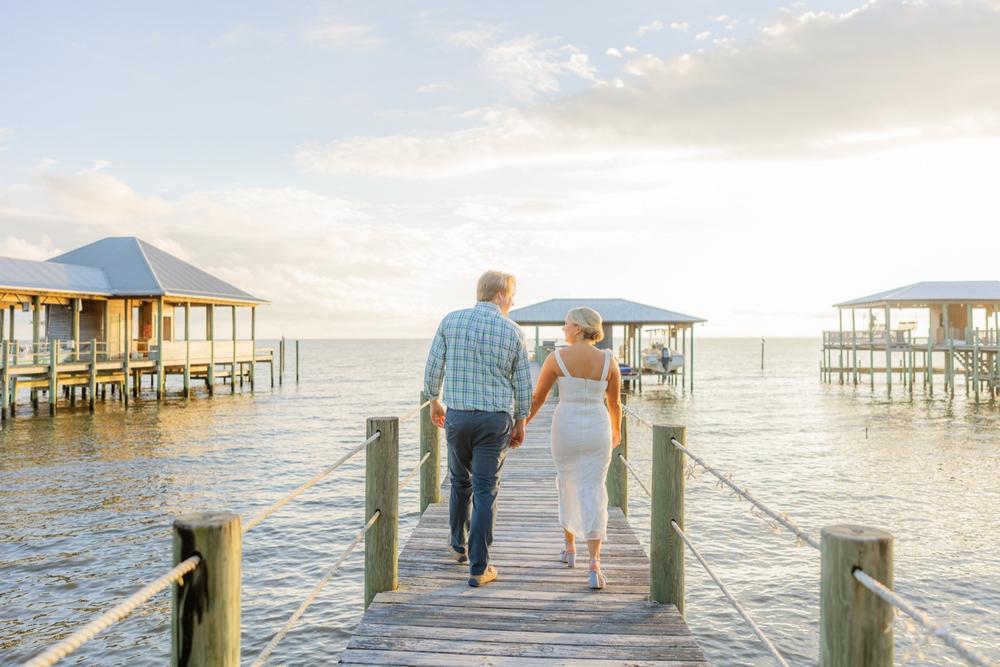 Romantic couple Audrey and Lyon, bathed in soft sunlight, share a loving moment beneath the mossy oak trees at the picturesque Grand Hotel in Fairhope.