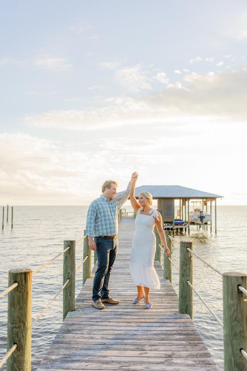 Romantic couple Audrey and Lyon, bathed in soft sunlight, share a loving moment beneath the mossy oak trees at the picturesque Grand Hotel in Fairhope.