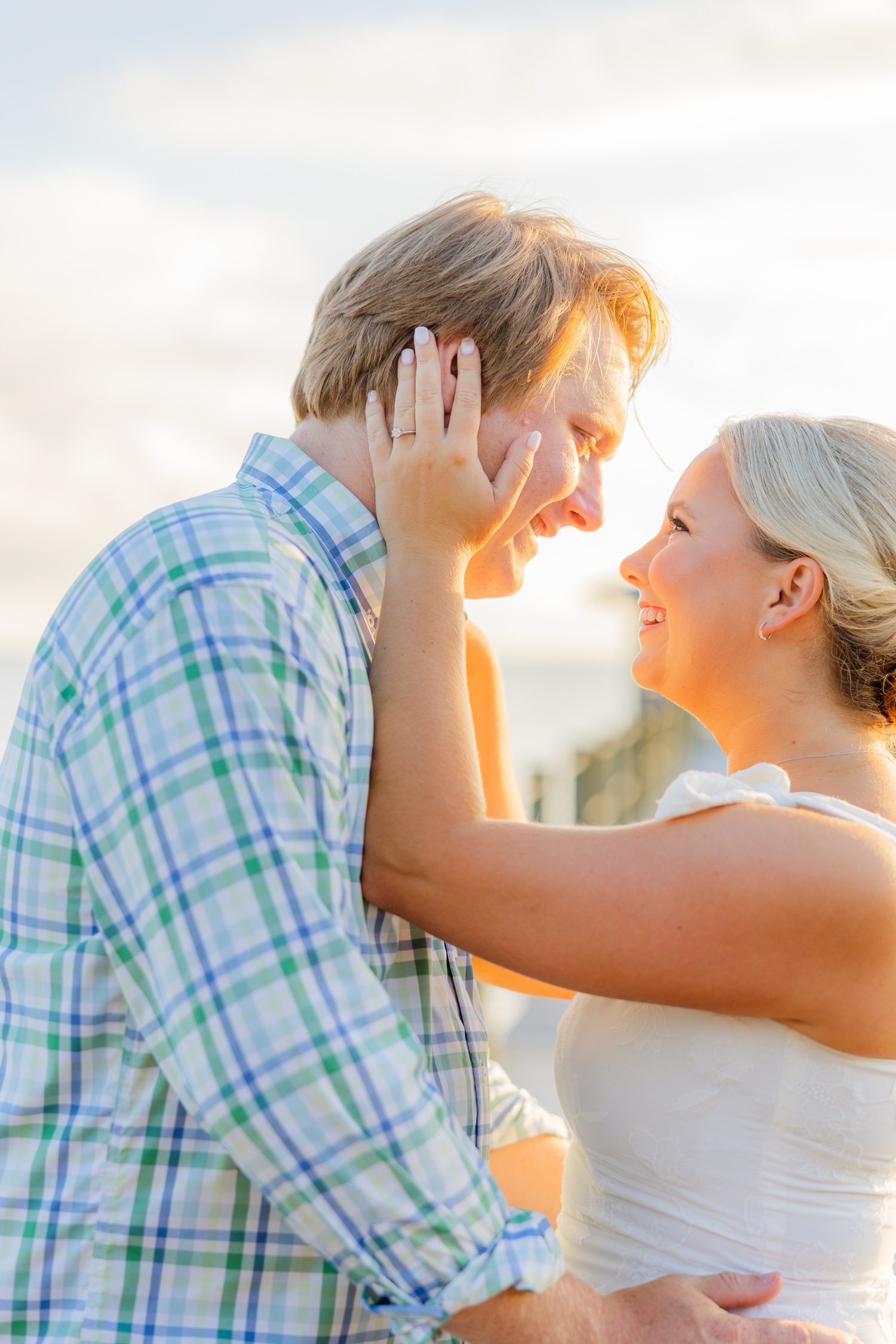 Romantic couple Audrey and Lyon, bathed in soft sunlight, share a loving moment beneath the mossy oak trees at the picturesque Grand Hotel in Fairhope.