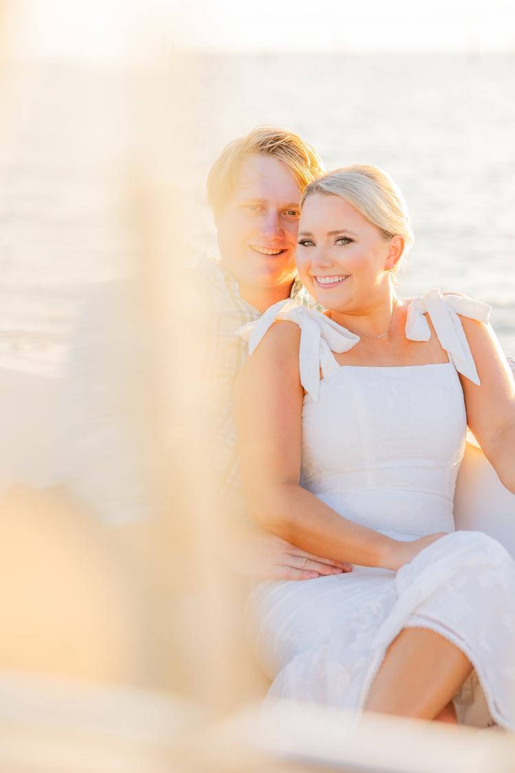 Romantic couple Audrey and Lyon, bathed in soft sunlight, share a loving moment beneath the mossy oak trees at the picturesque Grand Hotel in Fairhope.