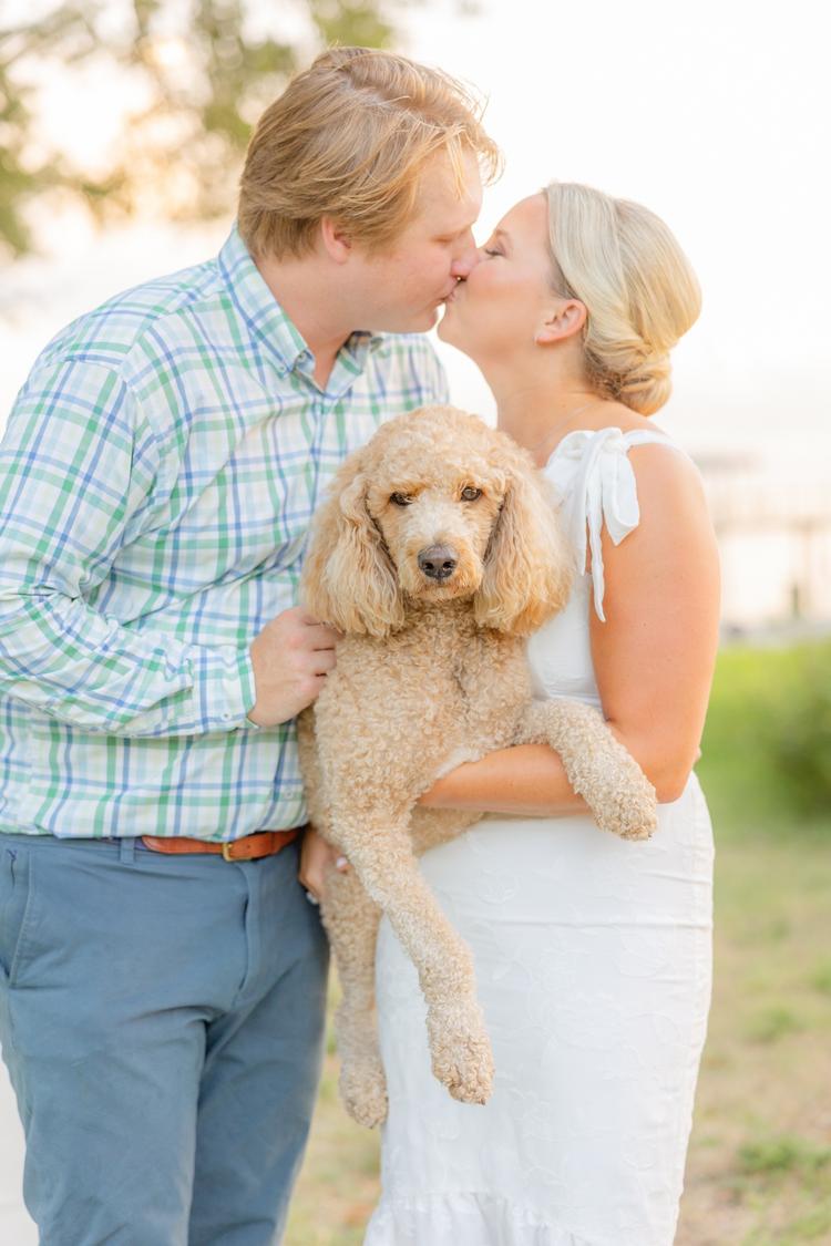 Romantic couple Audrey and Lyon, bathed in soft sunlight, share a loving moment beneath the mossy oak trees at the picturesque Grand Hotel in Fairhope.