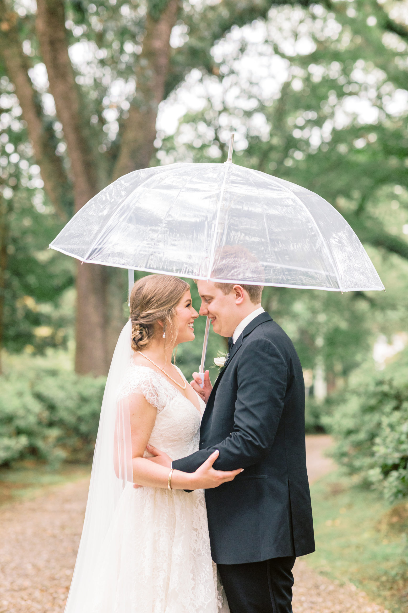 bride and groom at the Bragg Mitchell Mansion in Mobile, Alabama under an umbrella