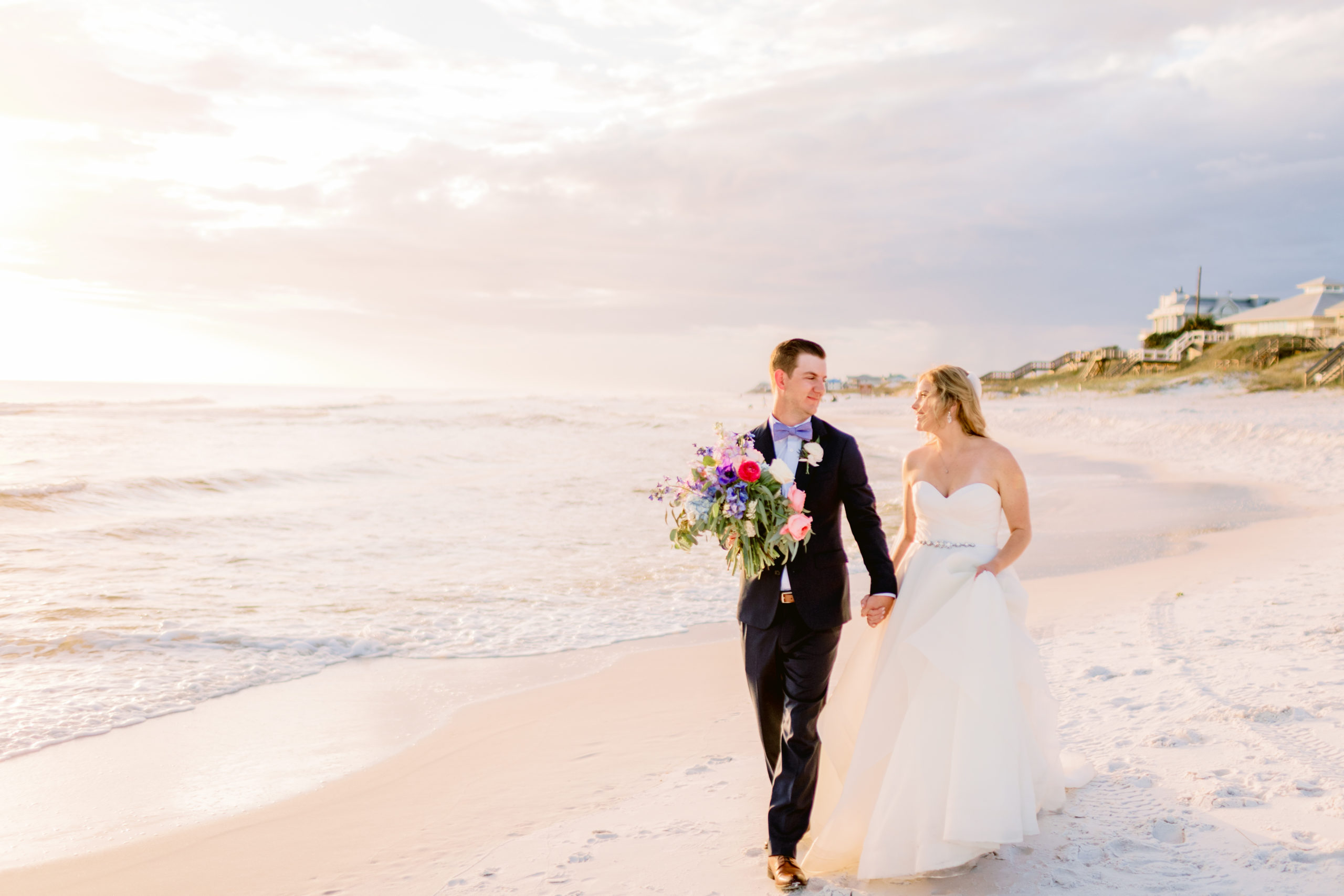 bride and groom on grayton beach walking