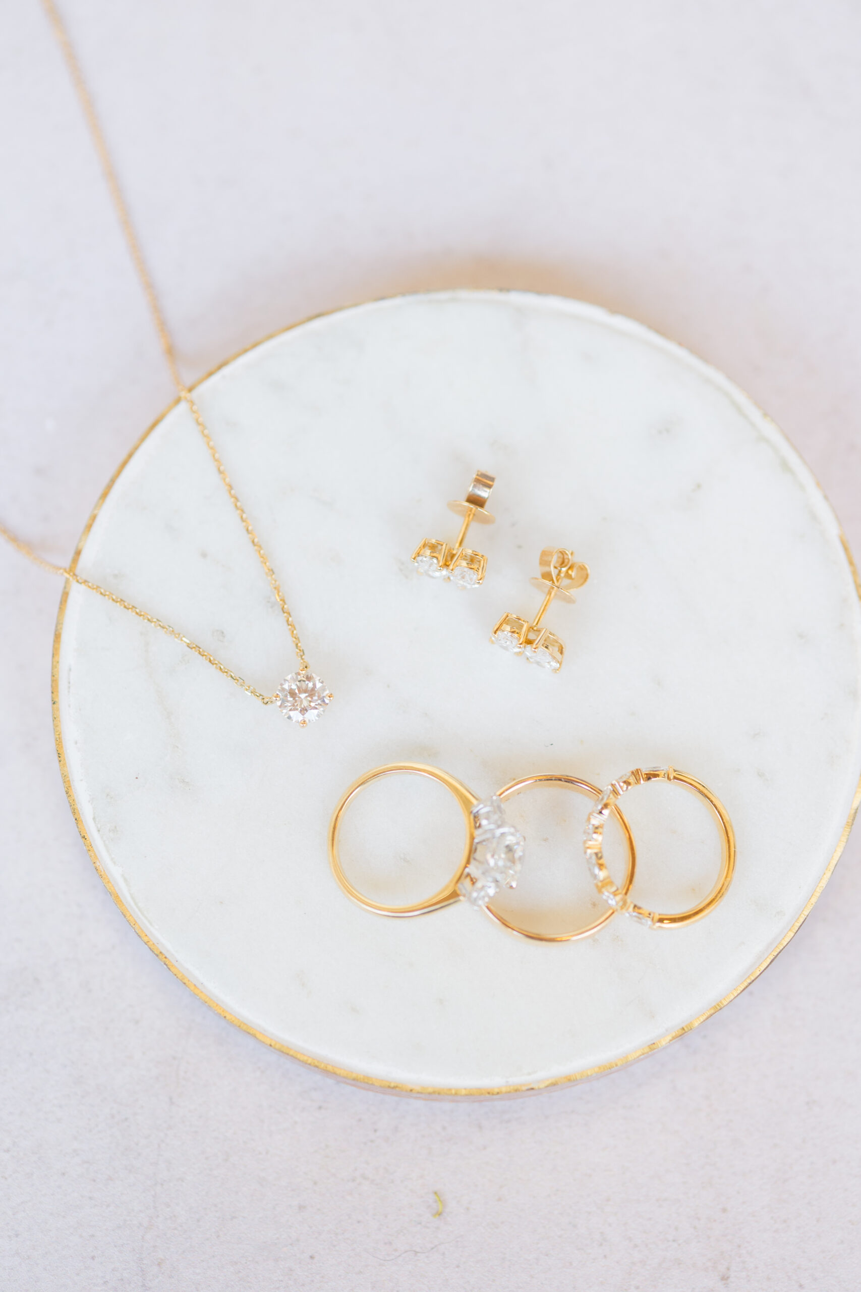 Elise bridal jewelry flat lay with gold rings and earrings on marble dish, Fairhope AL