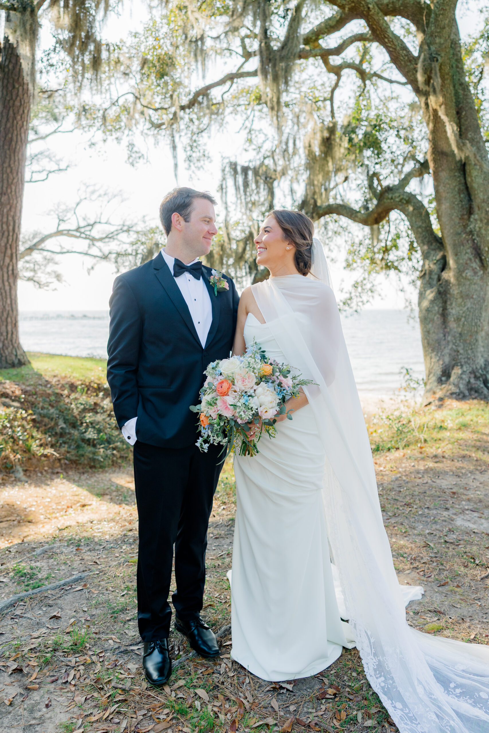 Elise and Michael wedding portraits under oak trees by the water in Fairhope, AL